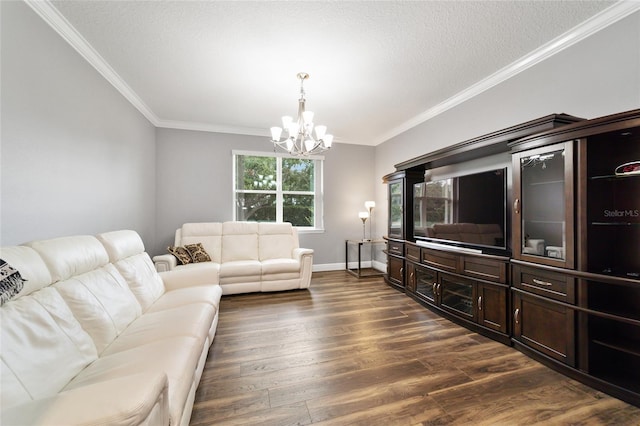 living room featuring a textured ceiling, ornamental molding, dark hardwood / wood-style floors, and an inviting chandelier