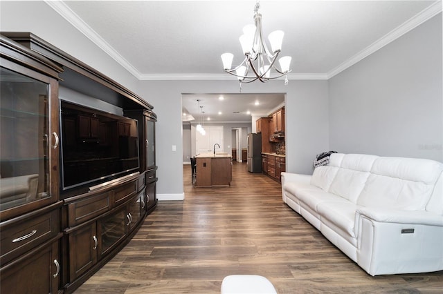 living room featuring an inviting chandelier, ornamental molding, sink, and dark wood-type flooring