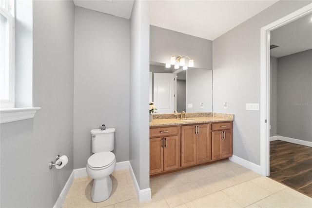 bathroom with tile patterned flooring, vanity, and toilet