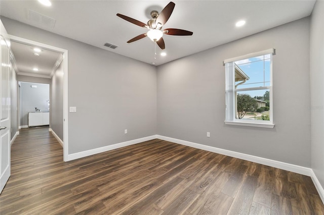 spare room with dark hardwood / wood-style flooring, ceiling fan, and crown molding