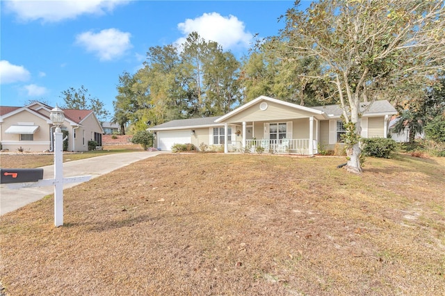 ranch-style home featuring covered porch, a front yard, and a garage