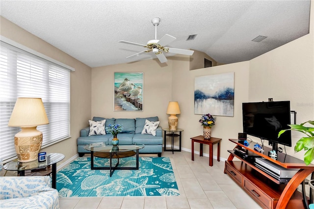 tiled living room featuring vaulted ceiling, ceiling fan, and a textured ceiling