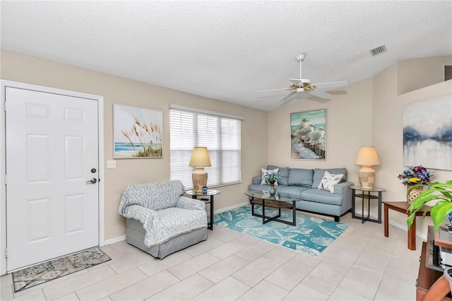 tiled living room featuring ceiling fan and a textured ceiling