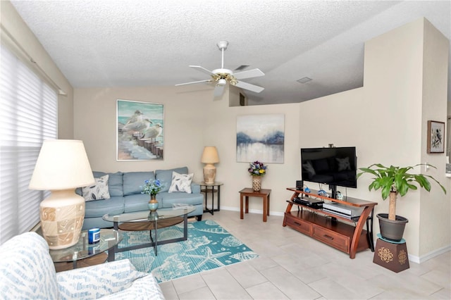 living room featuring vaulted ceiling, ceiling fan, light tile patterned flooring, and a textured ceiling