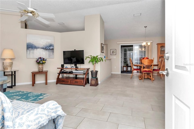 tiled living room featuring ceiling fan with notable chandelier, a textured ceiling, and vaulted ceiling