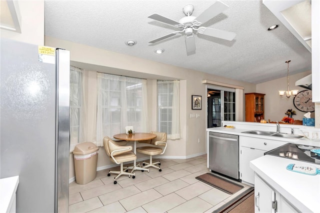 kitchen with pendant lighting, sink, white cabinetry, appliances with stainless steel finishes, and a textured ceiling