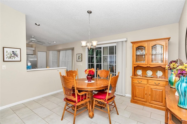 tiled dining room with vaulted ceiling, ceiling fan with notable chandelier, and a textured ceiling