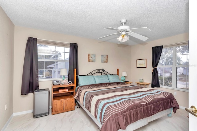 bedroom featuring ceiling fan and a textured ceiling