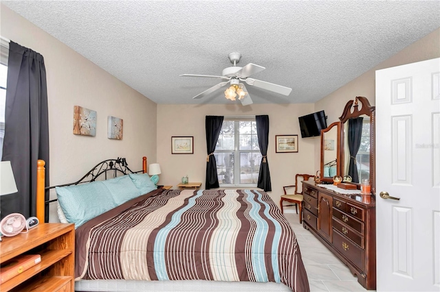 bedroom with ceiling fan and a textured ceiling