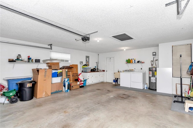 garage featuring washing machine and dryer, a garage door opener, and water heater