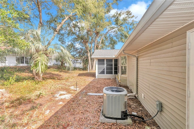 view of yard with central AC unit and a sunroom