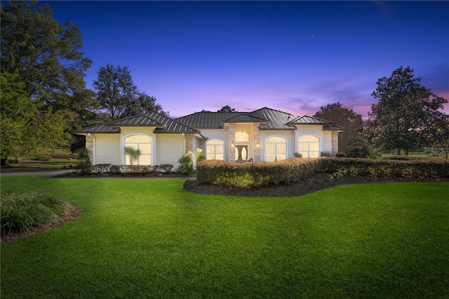 mediterranean / spanish-style house with a garage and a lawn