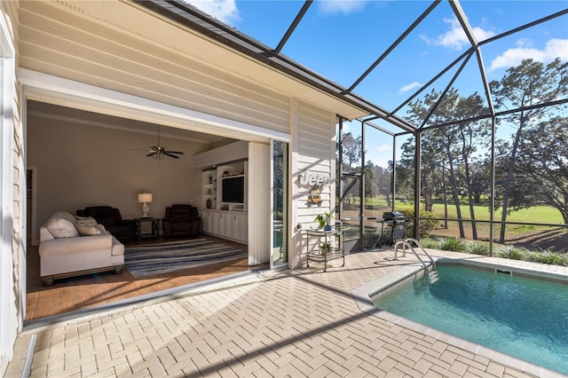 view of pool with a patio, glass enclosure, and ceiling fan