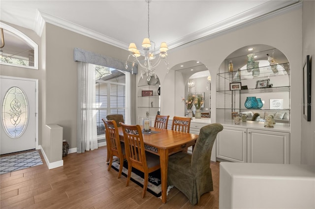 dining space with a notable chandelier, ornamental molding, and dark wood-type flooring