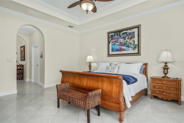 bedroom with ceiling fan, light tile patterned flooring, ornamental molding, and a tray ceiling