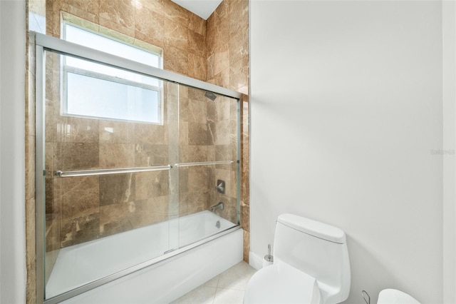 bathroom featuring shower / bath combination with glass door, tile patterned flooring, and toilet