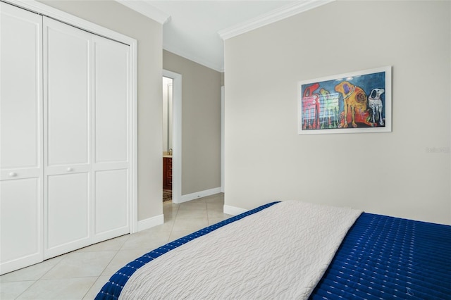 bedroom with a closet, light tile patterned floors, and ornamental molding