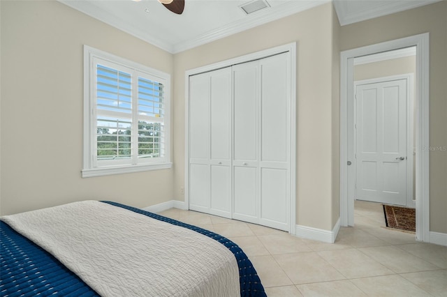 tiled bedroom featuring ceiling fan, a closet, and crown molding