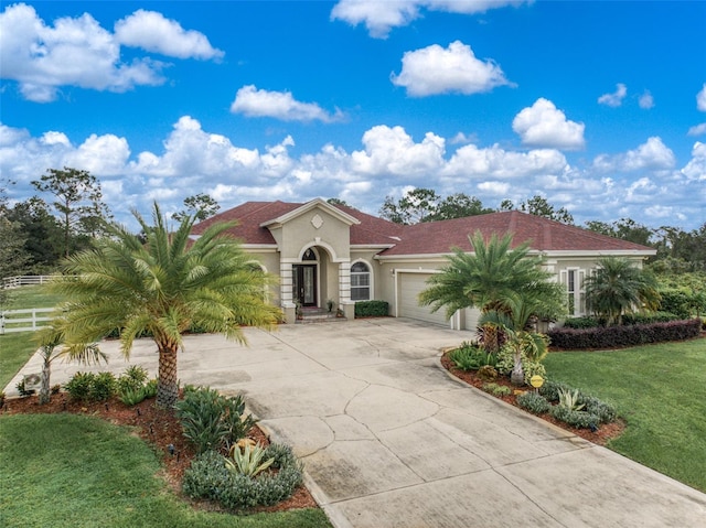 mediterranean / spanish home with a garage and a front lawn