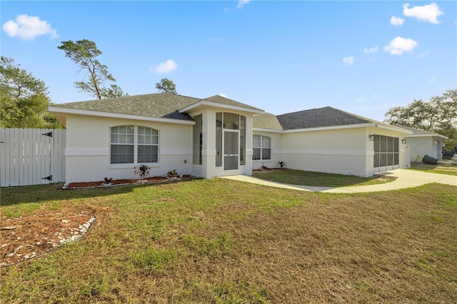 ranch-style home with a sunroom and a front lawn