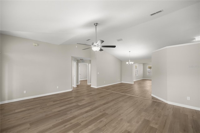 unfurnished living room featuring ceiling fan with notable chandelier, vaulted ceiling, and dark wood-type flooring