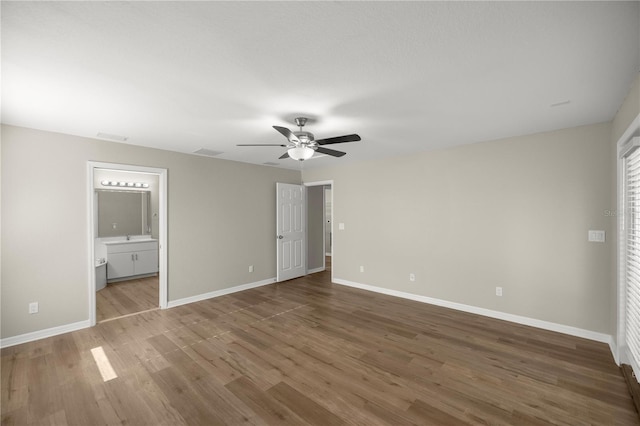 unfurnished bedroom with hardwood / wood-style flooring, ensuite bathroom, and ceiling fan