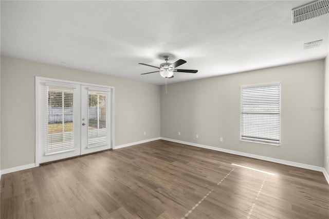 unfurnished room with ceiling fan, dark hardwood / wood-style flooring, and french doors