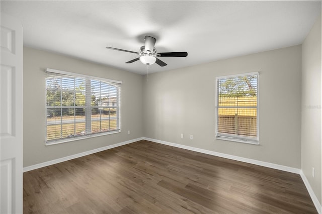 empty room with ceiling fan and dark hardwood / wood-style flooring