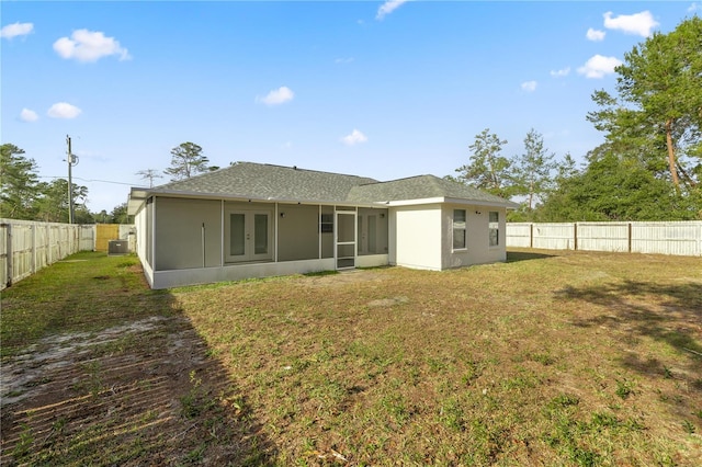 rear view of house with a sunroom and a yard