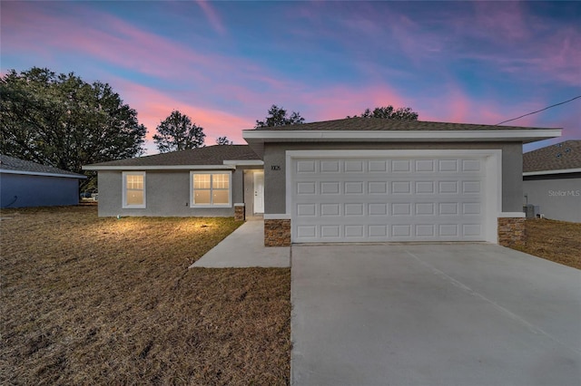 ranch-style house featuring stucco siding, concrete driveway, central AC, a garage, and stone siding