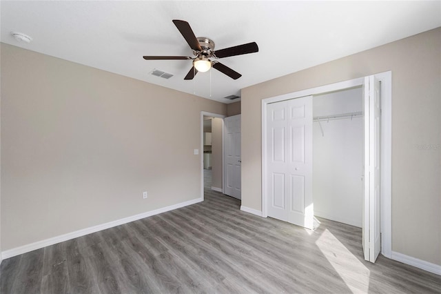 unfurnished bedroom with ceiling fan, light hardwood / wood-style floors, and a closet