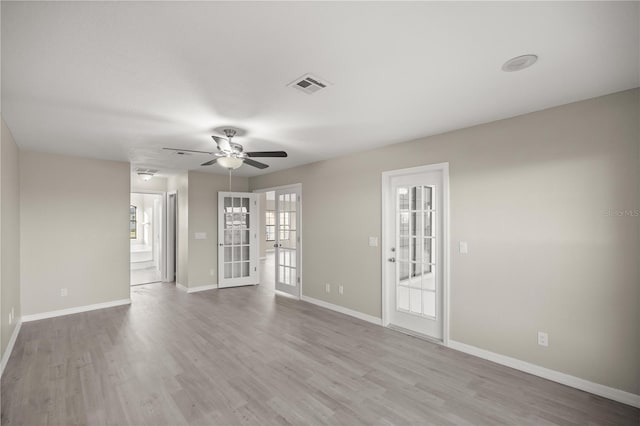 unfurnished room featuring ceiling fan, french doors, and light wood-type flooring