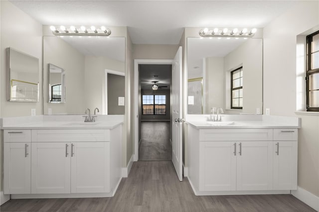 bathroom with ceiling fan, hardwood / wood-style floors, vanity, and a shower with shower door