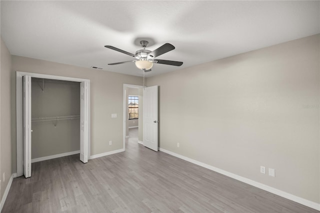 unfurnished bedroom with ceiling fan, a closet, and light hardwood / wood-style floors