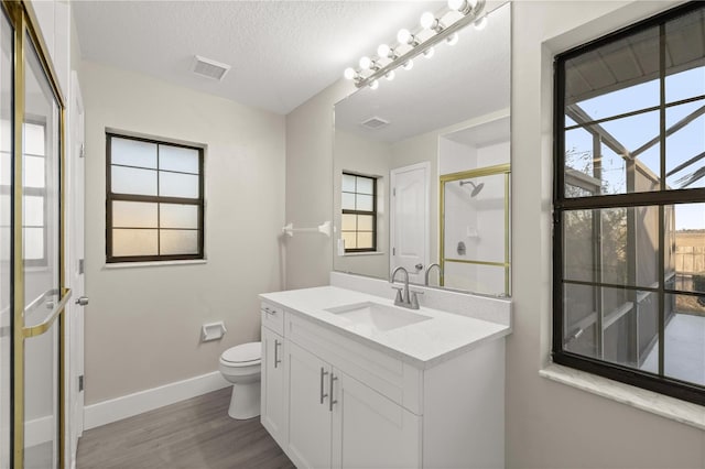 bathroom with vanity, toilet, wood-type flooring, and a textured ceiling