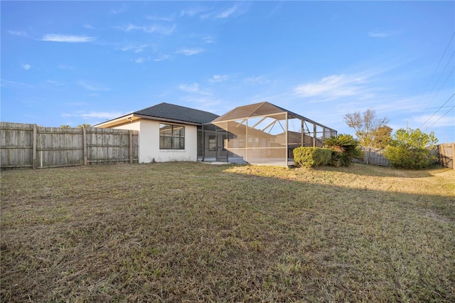 rear view of house with a lanai and a lawn