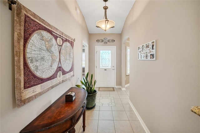 doorway with light tile patterned flooring and vaulted ceiling