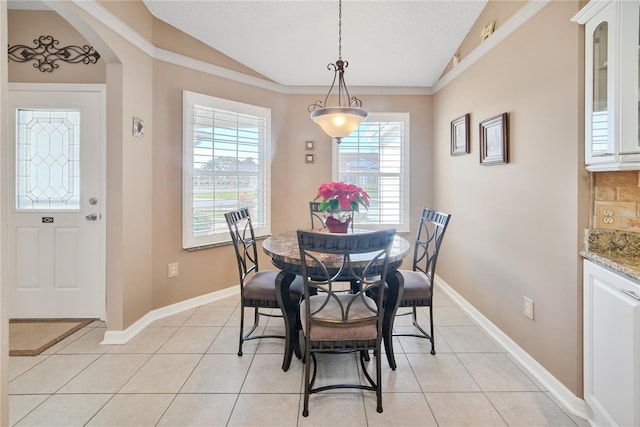 tiled dining space featuring vaulted ceiling