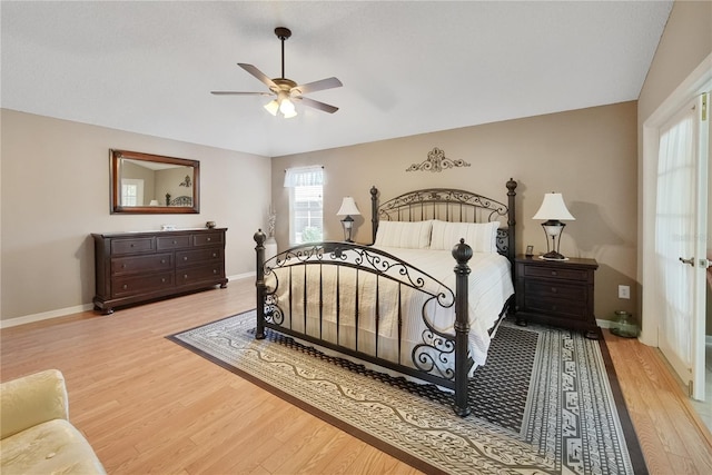 bedroom with ceiling fan, vaulted ceiling, and light wood-type flooring