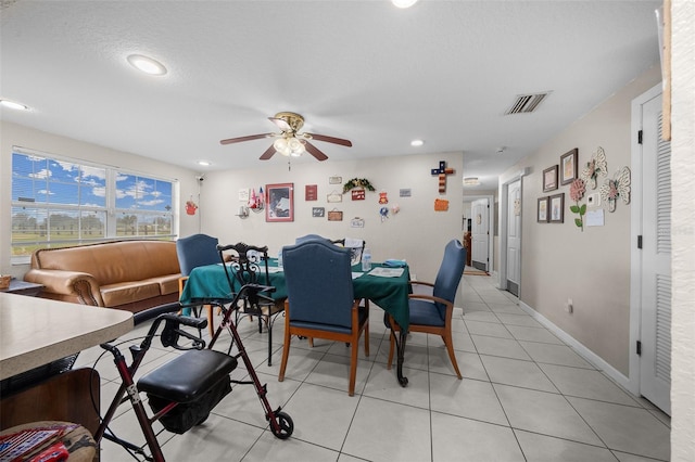 tiled dining area featuring a textured ceiling and ceiling fan