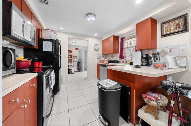 kitchen with light tile patterned floors, sink, stainless steel appliances, tasteful backsplash, and kitchen peninsula