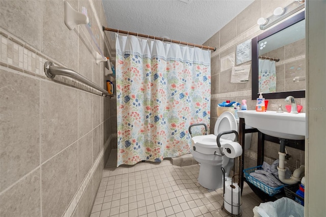 bathroom with tile walls, tile patterned flooring, toilet, a textured ceiling, and a shower with curtain