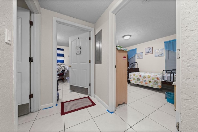 corridor featuring a textured ceiling and light tile patterned floors