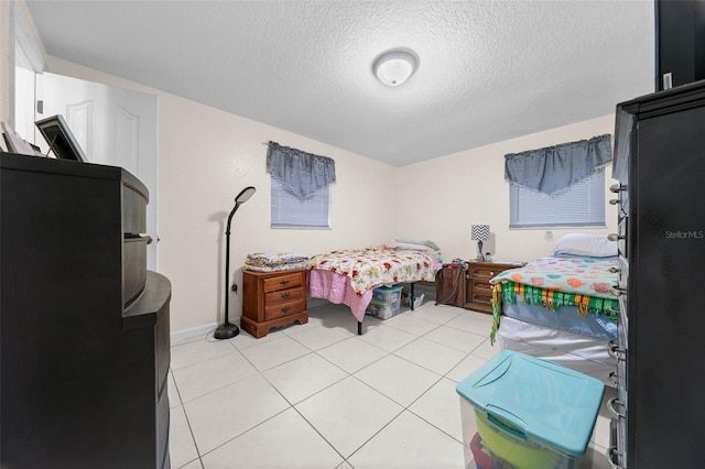 bedroom featuring a textured ceiling and light tile patterned floors