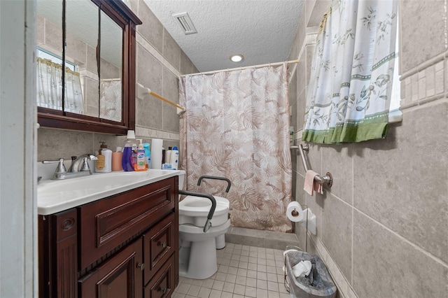 bathroom with tile patterned flooring, vanity, a textured ceiling, toilet, and walk in shower