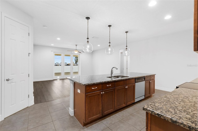 kitchen featuring stainless steel dishwasher, ceiling fan, sink, a center island with sink, and hanging light fixtures