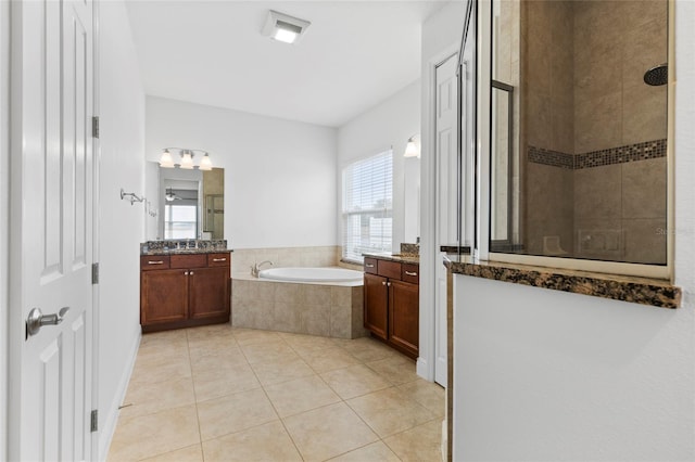 bathroom featuring tile patterned flooring, shower with separate bathtub, and vanity