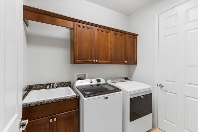 washroom with washer and dryer, sink, and cabinets