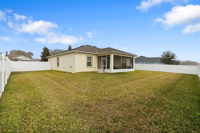 rear view of house with a sunroom and a lawn