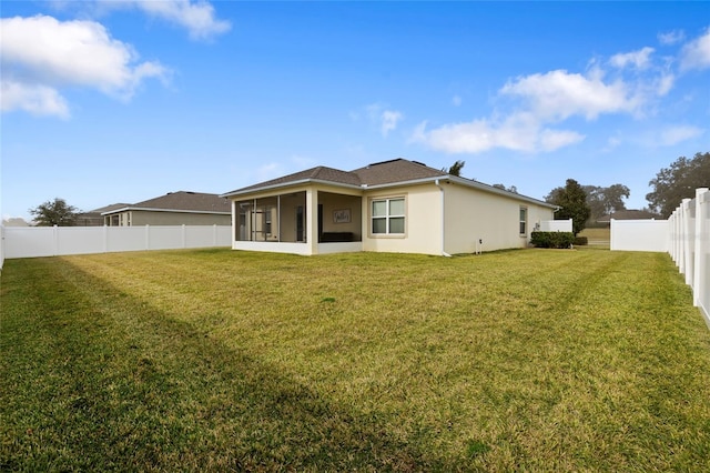 rear view of property with a yard and a sunroom